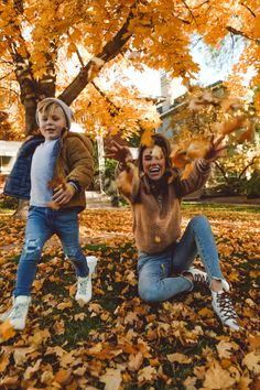 two young children playing in the leaves