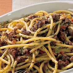 a white bowl filled with pasta and meat