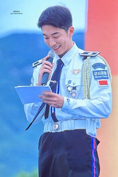 a man in uniform is holding a microphone