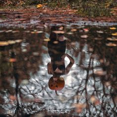 a woman standing in the water holding a pumpkin