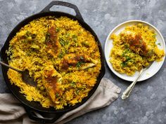 a pan filled with chicken and rice next to a plate of food on a table