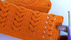 an orange crochet scarf being worked on