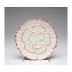 a white and pink plate with a flower on it