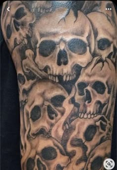 a man's arm with skulls on it and one skull is in the middle