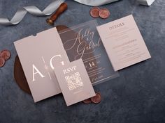 the wedding stationery is laid out on top of some coins and paper with ribbons around it