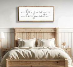 a bed with white sheets and pillows in a bedroom next to a wooden headboard