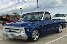 a blue truck parked in a parking lot next to other cars