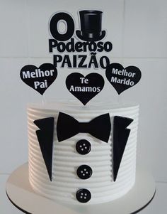 a white cake with black and white decorations on it's top tier is decorated with an image of a tuxedo