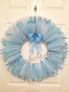 a blue tulle wreath hanging on the front door with a bow and ribbon around it