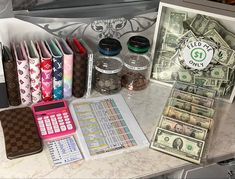 a counter topped with lots of money and calculator next to a card case