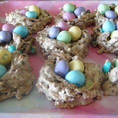 several cookies with chocolate eggs in them on a pink and white plate