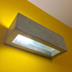 a light that is on the side of a wall in a room with yellow walls