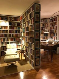 a living room filled with lots of books on top of a hard wood flooring