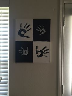 three hand prints hanging on the wall above a toilet in front of a window with blinds