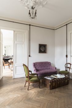 a living room filled with furniture and a chandelier