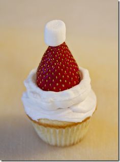 a cupcake with white frosting and a strawberry on top