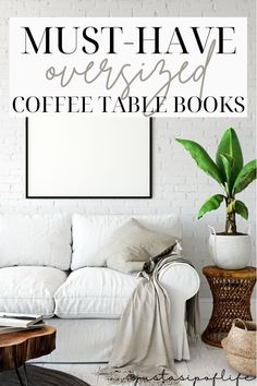 a white couch sitting next to a table with a potted plant on top of it