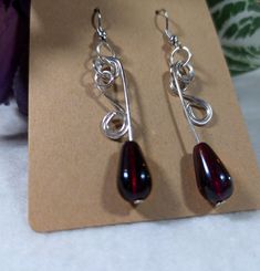 Red Glass Bead Dangle Earrings are handmade and secured with silver plated hypoallergenic hardware.  The Red Glass Bead earrings are wire wrapped with silver hardware adding a touch of elegance. The Deep Red beads are gorgeous in person seriously these pictures do not do them justice!  They are perfect for a night out. The deep red beads with unique hand wrapped silver wire design takes these earrings to the next level. A unique and rare handmade design be sure to grab them before they're gone! Red Wire Wrapped Drop Earrings, Red Wire Wrapped Dangle Earrings, Red Wire Wrapped Metal Earrings, Red Sterling Silver Wire Wrapped Earrings, Red Sterling Silver Beaded Earrings, Hypoallergenic Red Metal Earrings, Red Nickel-free Teardrop Dangle Earrings, Red Wire Wrapped Earrings For Party, Handmade Adjustable Red Teardrop Earrings