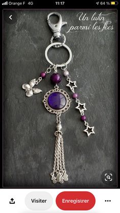 a keychain with a purple stone and charms hanging from it's side