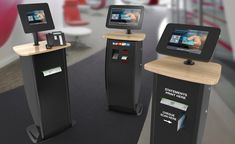 three electronic kiosks are shown in an office setting with two screens on them