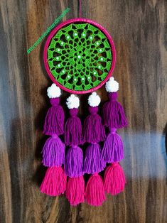 a green and purple decoration hanging from a wooden table