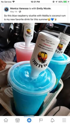 two plastic cups filled with blue liquid sitting on top of a table