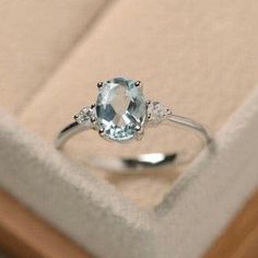 an oval aquamarinee and diamond ring in a box