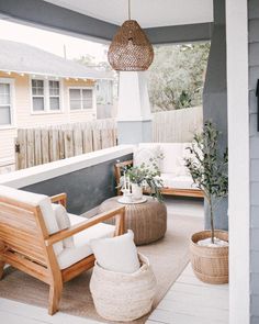 an outdoor living area with wicker furniture and potted plants on the porch,