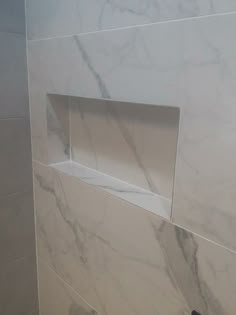 a bathroom with white marble walls and floor