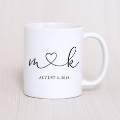 a white coffee mug with the word n and k on it, sitting on a table