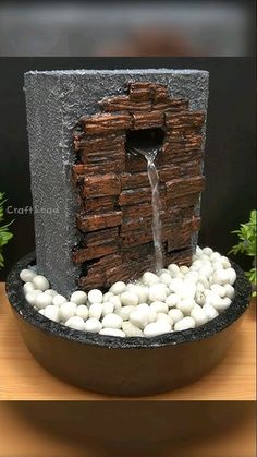 a fountain made out of rocks and stones with water coming from the hole in it