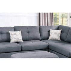 a gray sectional couch with pillows on it