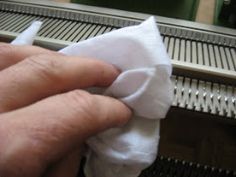 a person holding something in their hand near a conveyor belt with other machines behind them