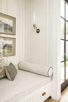 a white daybed with pillows on it in front of a sliding glass door