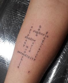 a person with a tattoo on their arm that has words all over it and the word is written in cursive writing