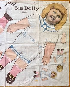 a child's paper doll laying on top of a piece of white paper with blue and pink designs