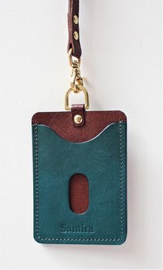 a card holder with a keychain hanging from it's front loop and the name simina on it