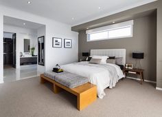 a large white bed sitting in the middle of a bedroom