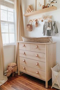 a baby's room with a dresser, teddy bear and other items on the wall