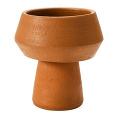 a brown vase sitting on top of a white surface