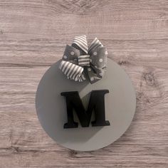 the letter m is placed on top of a plate with a bow tied to it