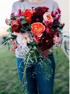 a woman holding a bouquet of flowers in her hands