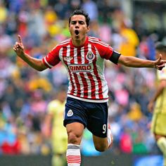 a soccer player with his mouth wide open and hands out in the air as he runs