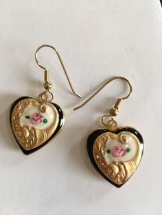 "Simply beautifully retro and classic These pretty earrings would make the perfect gift for a birthday present, Mother's Day gift or Graduation present, Valentines Day.... or just because. These hand enameled lavender and cream vintage enamel earrings are hand painted with pink rosettes and green leaves. The hearts are washed in 14K gold and are accented with complimentary antique Czech glass beads The earrings open and close securely to hold a secret treasure and measure 3/4 \" x 3/4\" . They d