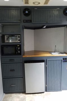 a kitchen with gray cabinets and white walls