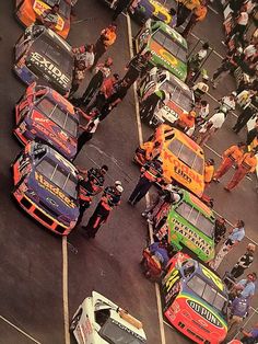 many cars are parked in a parking lot with people standing around and looking at them