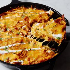 a skillet filled with lasagna covered in cheese and parmesan sauce