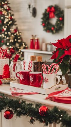 red and white mugs with candy canes in them sitting on a mantle next to a christmas tree