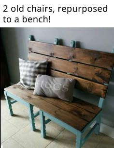 a wooden bench sitting next to a wall with two pillows on it's back