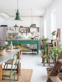 the kitchen is decorated in green and has lots of potted plants on the counter